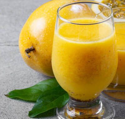 Glass with passion fruit juice and sliced passion fruit on the table.